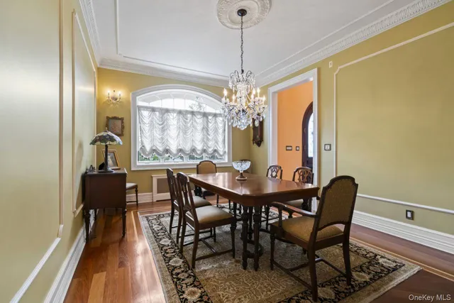 a dining room with furniture a chandelier and wooden floor