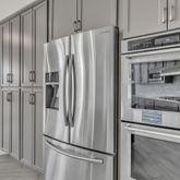 a metallic refrigerator freezer sitting in a kitchen
