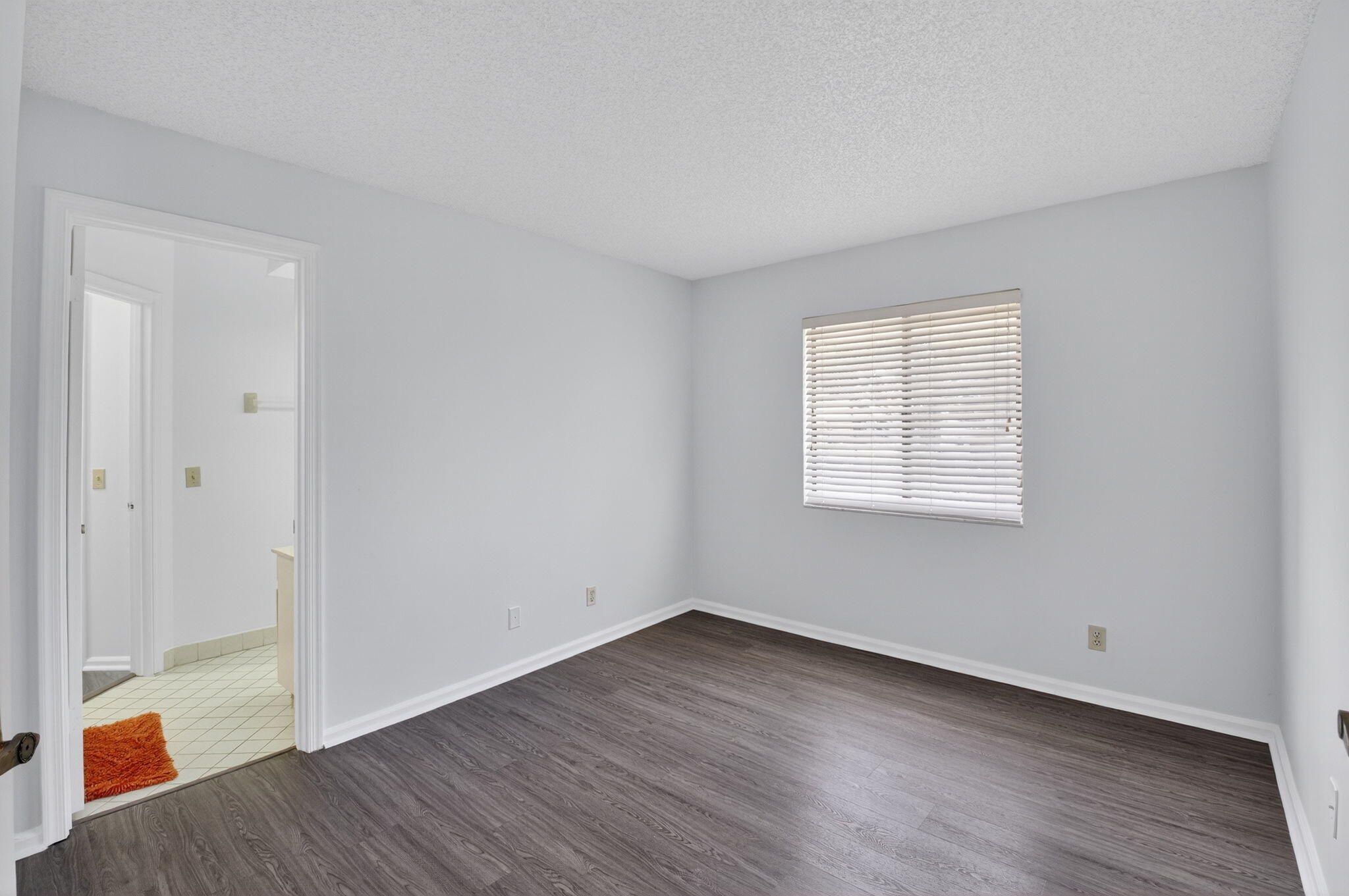 5530 Coach House Circle, Unit E Boca Raton, FL 33486 - Photo 18 of 40 an empty room with wooden floor and windows