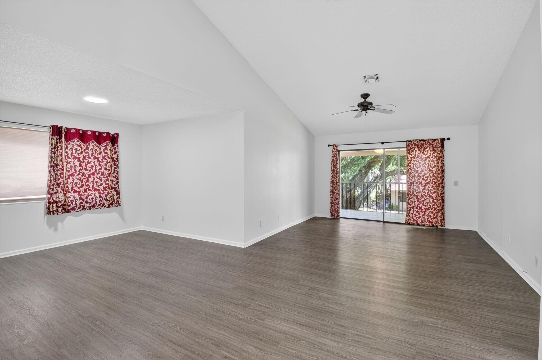 5530 Coach House Circle, Unit E Boca Raton, FL 33486 - Photo 5 of 40 an empty room with wooden floor and windows