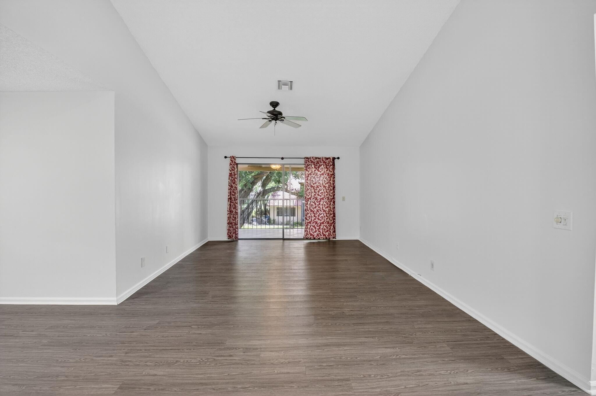 5530 Coach House Circle, Unit E Boca Raton, FL 33486 - Photo 6 of 40 a view of an empty room with wooden floor and a window