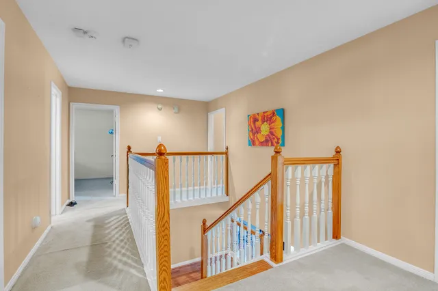 a view of a hallway with wooden floor and stairs