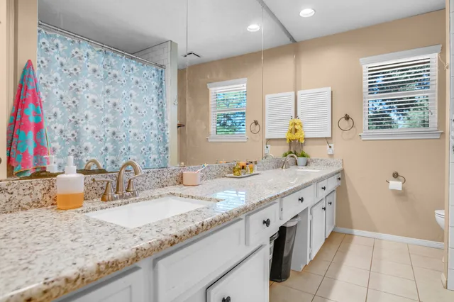 a bathroom with a granite countertop sink a large mirror and a bathtub