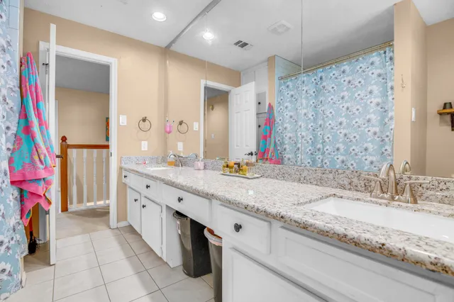 a bathroom with a granite countertop sink a mirror and a shower