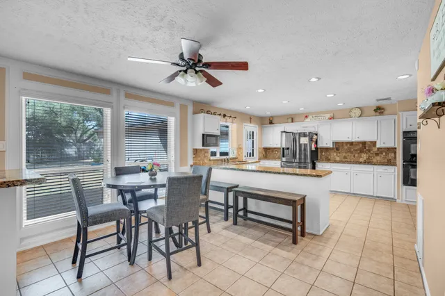 a living room with stainless steel appliances kitchen island granite countertop furniture and a large window
