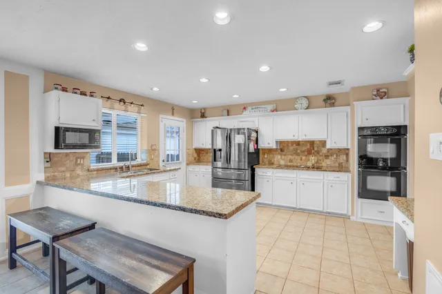 a large kitchen with stainless steel appliances granite countertop a large counter top and a stove