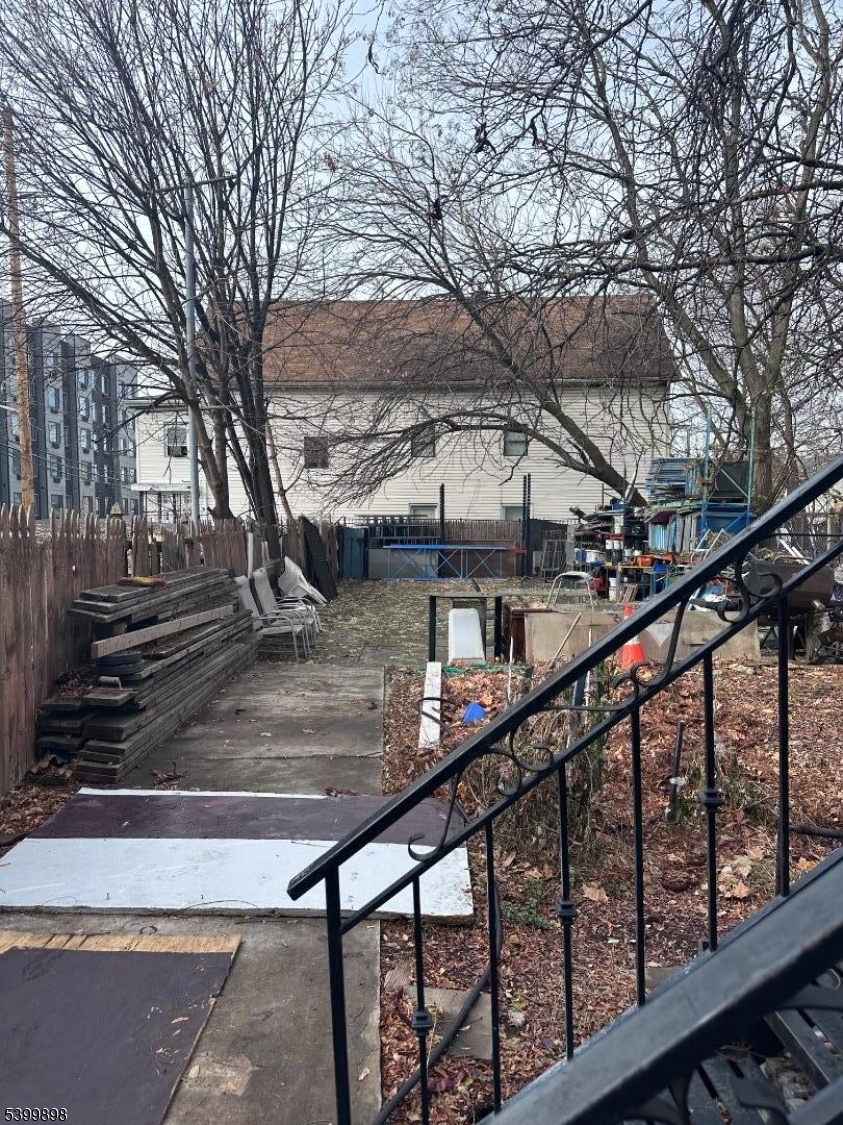 152 Jaques Street Elizabeth, NJ 07201 - Photo 23 of 23 a view of house with large trees and wooden fence