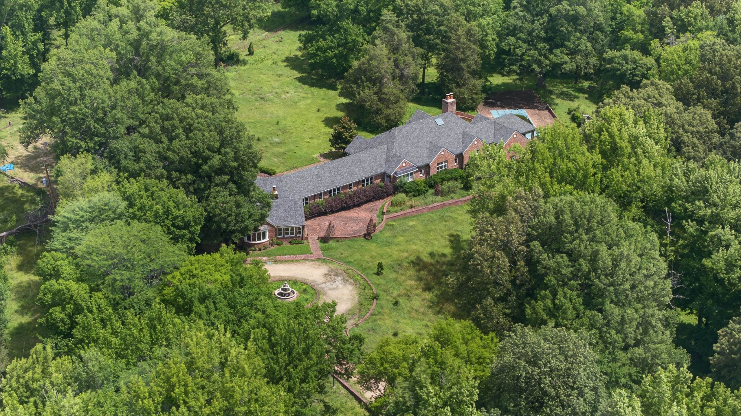 530 West Raines Road Memphis, TN 38109 - Photo 10 of 38 Expansive property featuring a brick exterior residence with a dark shingle roof, surrounded by mature trees