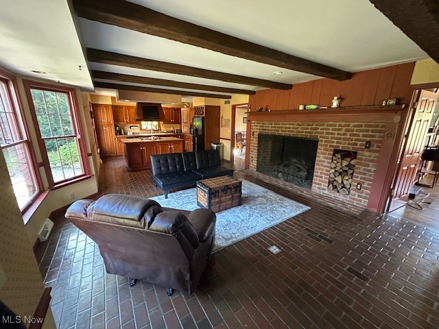 1975 Warner Road Southeast Hubbard, OH 44425 - Photo 9 of 23 Living room featuring brick floors, beam ceiling, and a brick fireplace