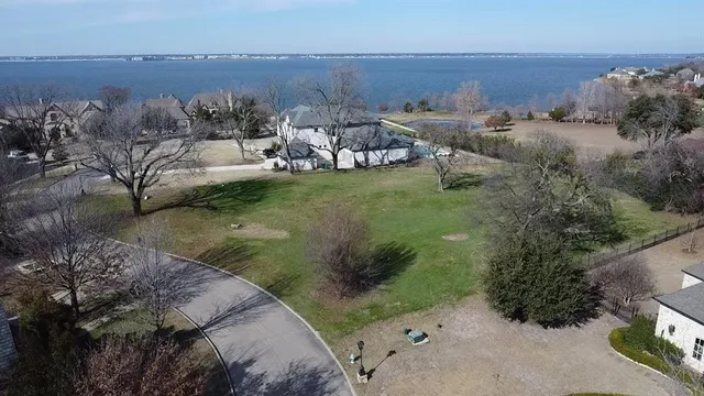 aerial view of a house with a yard and lake view