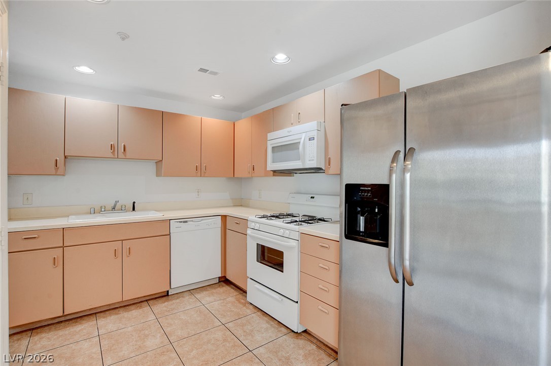 230 East Flamingo Road, Unit 404 Las Vegas, NV 89169 - Photo 13 of 34 Tiled flooring and flush recessed lighting complement the clean cabinetry lines in this kitchen.