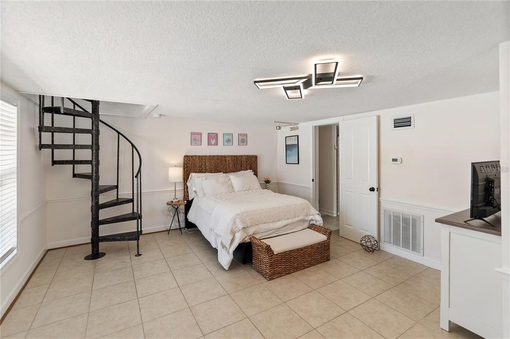 861 Nectar Road Venice, FL 34293 - Photo 50 of 74 a spacious bedroom with a bed and a flat screen tv