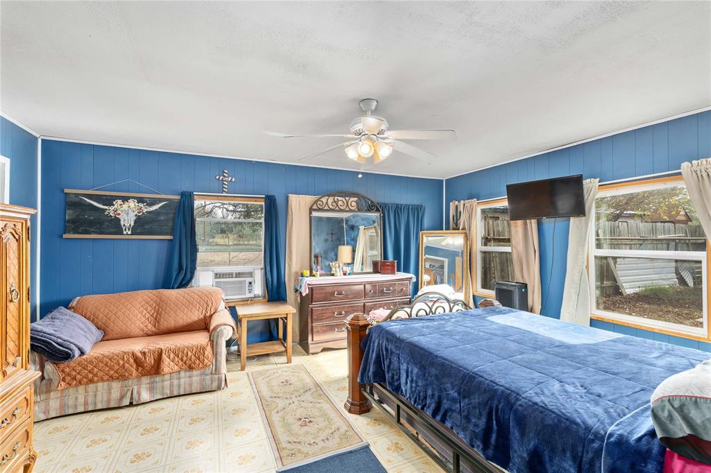 309 Goodwin Street Bangs, TX 76823 - Photo 11 of 20 Bedroom with ceiling fan and wooden walls