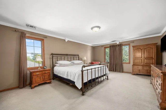 a room with a bed window and dresser