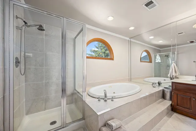 a bathroom with a tub a sink and mirror