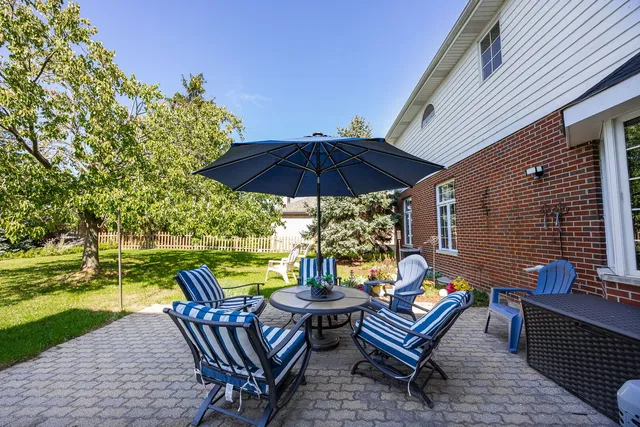 a view of a chairs and table in the patio with a umbrella