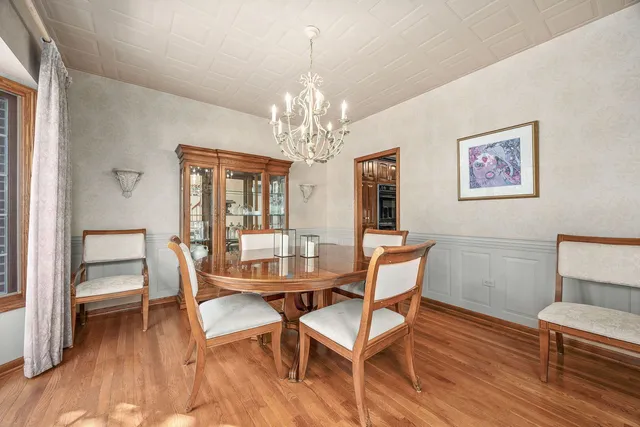 a dining room with furniture a chandelier and wooden floor
