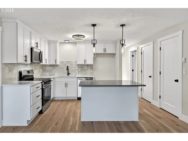 a kitchen with stainless steel appliances cabinets a sink and a counter top space