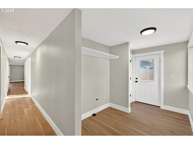 a view of an empty room with wooden floor