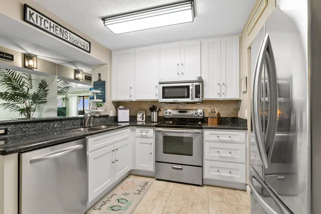 a kitchen with stainless steel appliances granite countertop a refrigerator stove and sink