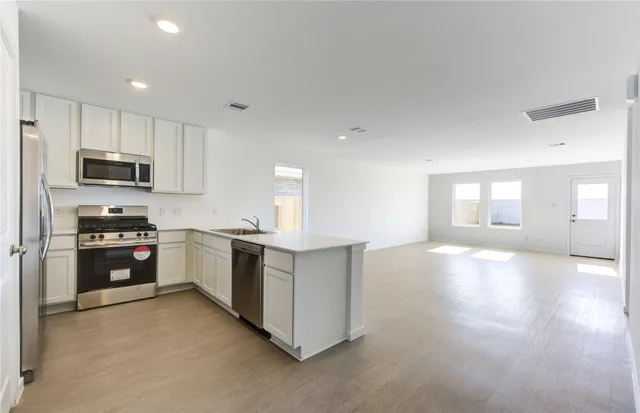 a kitchen with stainless steel appliances a refrigerator stove and microwave