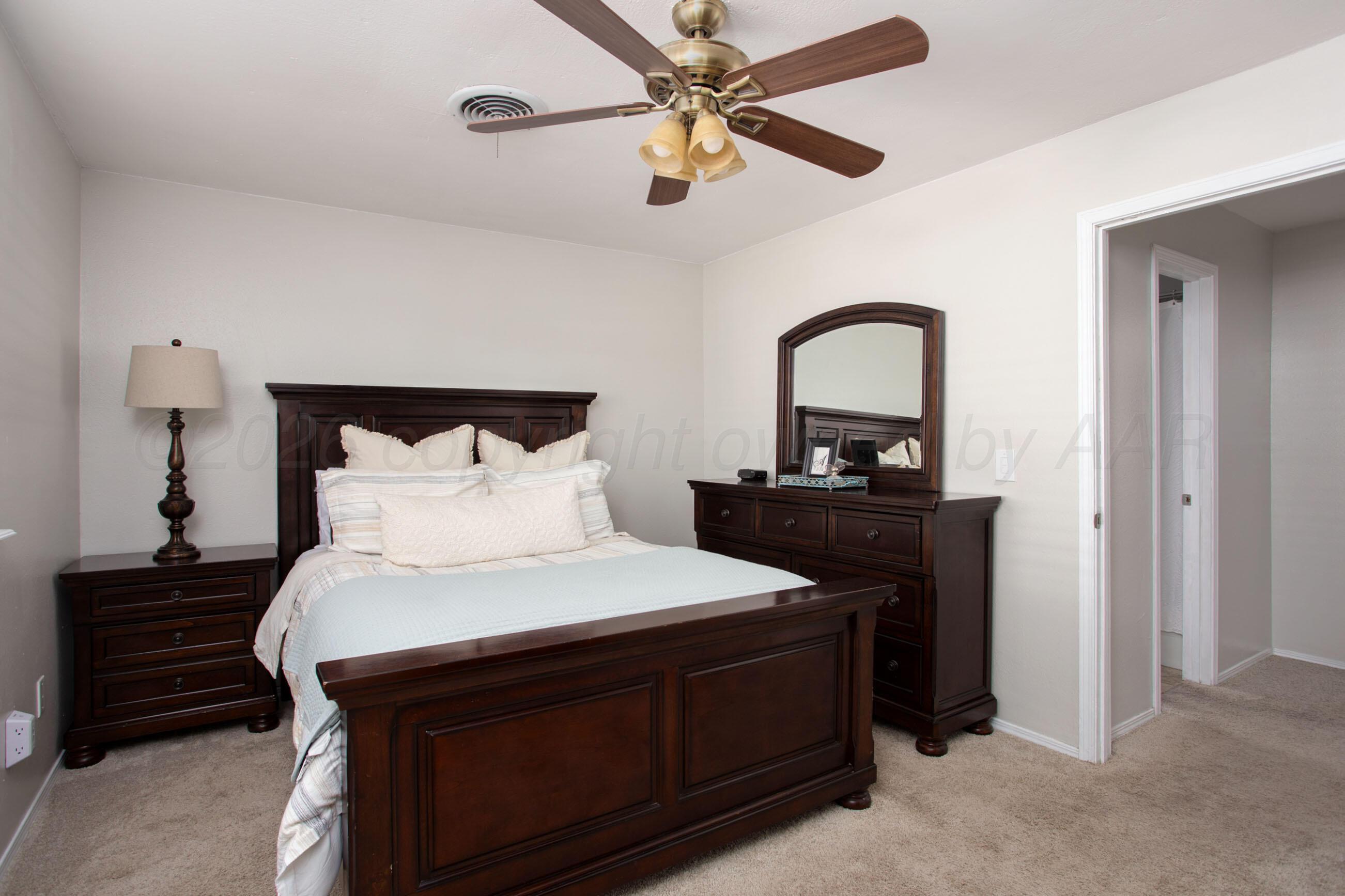 7924 Simpson Drive Amarillo, TX 79121 - Photo 14 of 33 a bedroom with a bed and a mirror on dresser