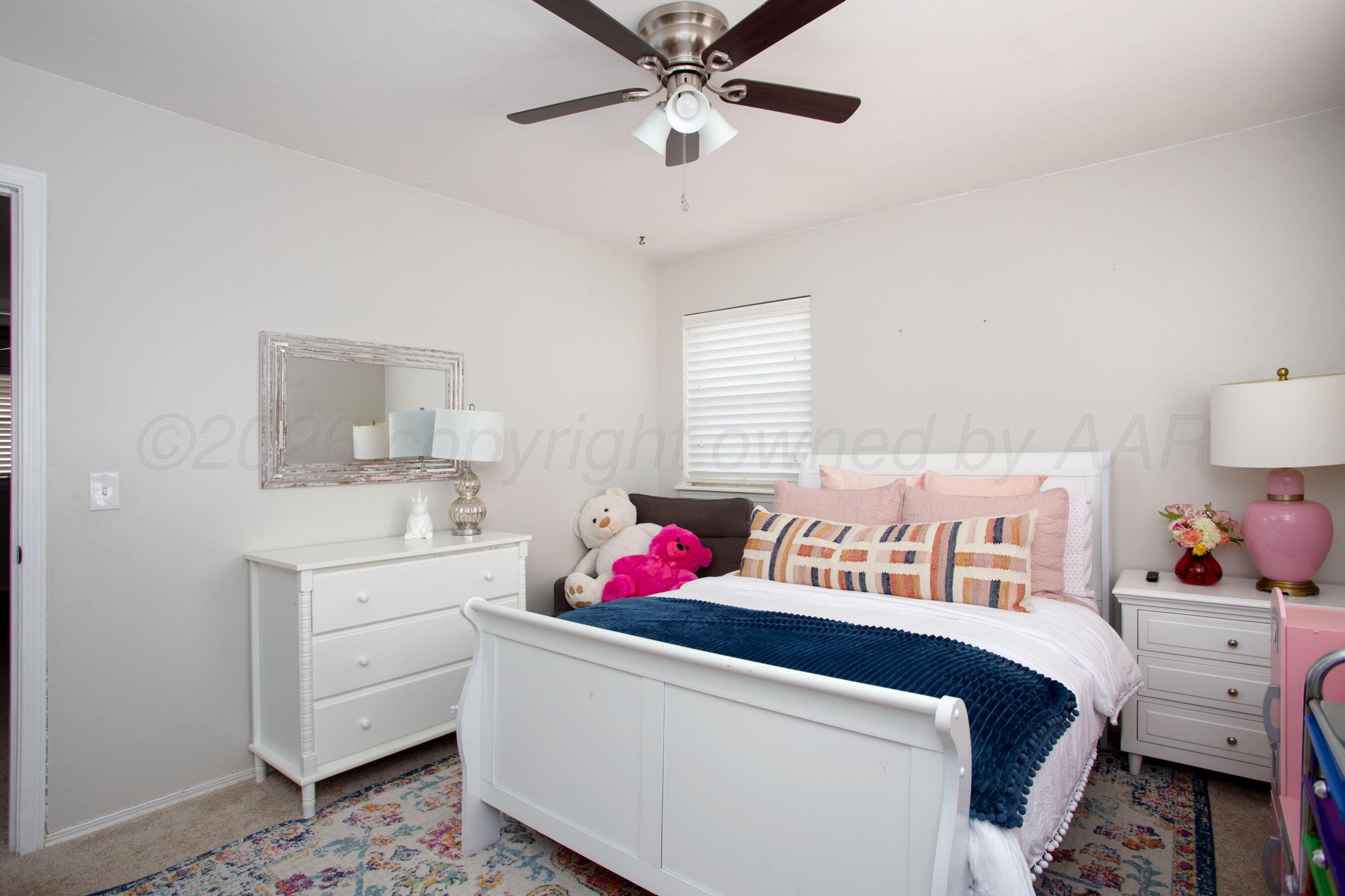 7924 Simpson Drive Amarillo, TX 79121 - Photo 17 of 33 a bedroom with a bed and a chandelier