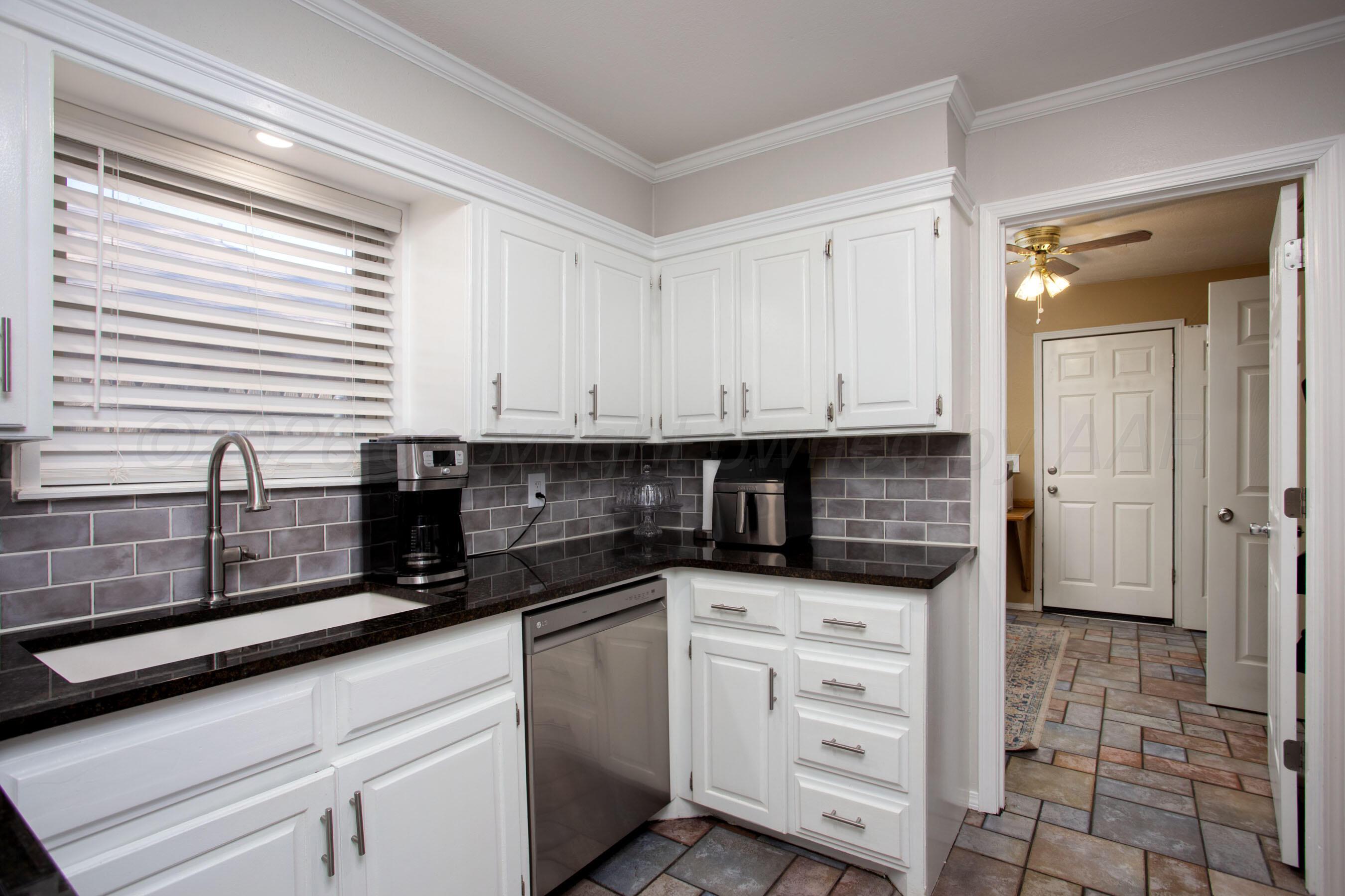 7924 Simpson Drive Amarillo, TX 79121 - Photo 8 of 33 a kitchen with granite countertop white cabinets and white appliances