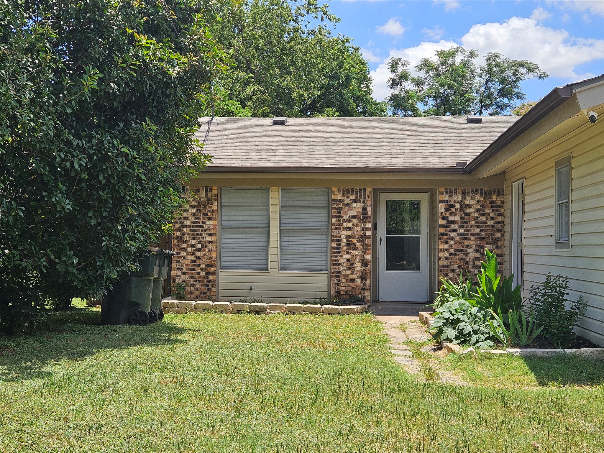 806 Ranch Road, Unit A Georgetown, TX 78628 - Photo 1 of 24 A classic brick and siding home awaits, nestled amidst lush greenery.