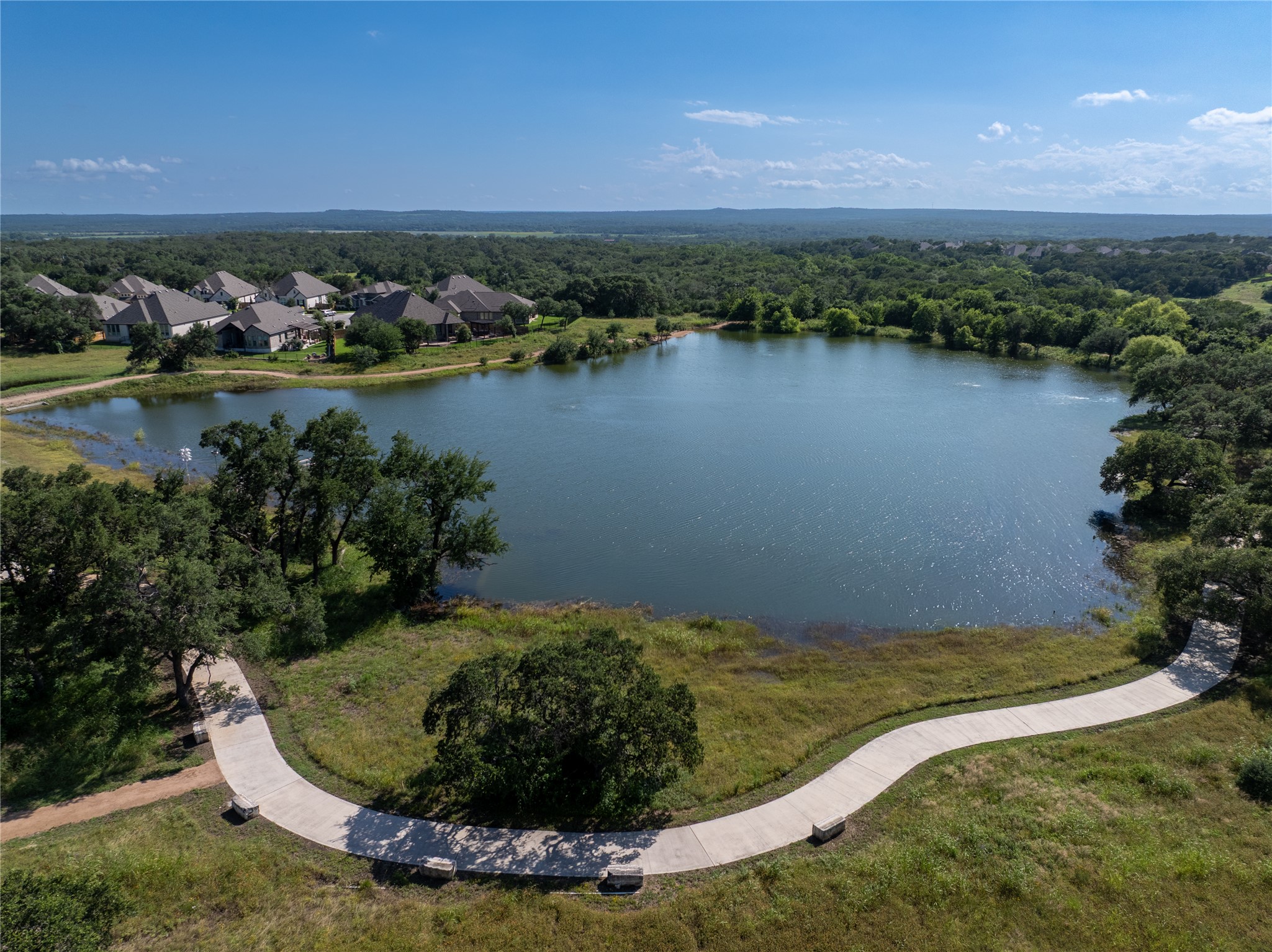 294 Kimble Creek Loop Kyle, TX 78640 - Photo 31 of 40 A picturesque lakefront community with winding paths and lush natural surroundings.