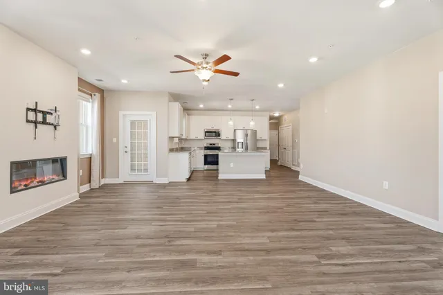 a view of kitchen with a refrigerator a ceiling fan and wooden floor