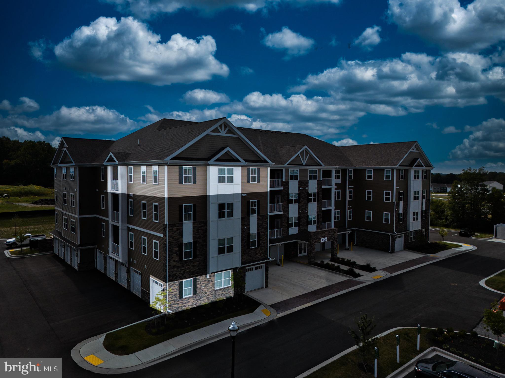 406 Bold Ruler Court, Unit 402 Havre de Grace, MD 21078 - Photo 3 of 43 Modern apartment complex under a dramatic sky.