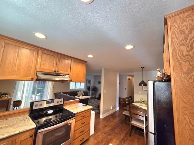 a kitchen with stainless steel appliances granite countertop a stove a sink and a refrigerator