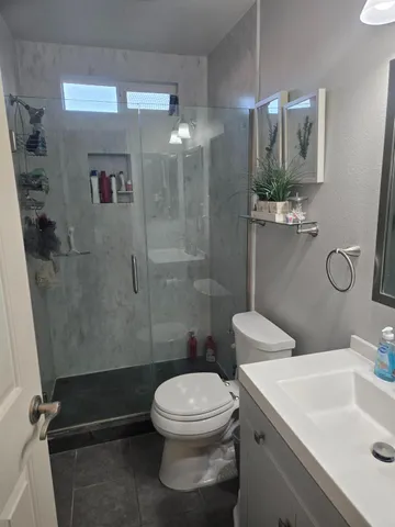 a white toilet sitting next to a bathroom sink