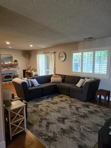 a living room with furniture kitchen view and a window