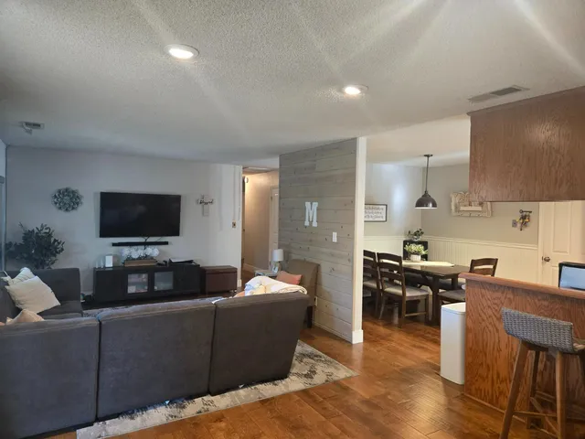 a living room with furniture wooden floor and a flat screen tv