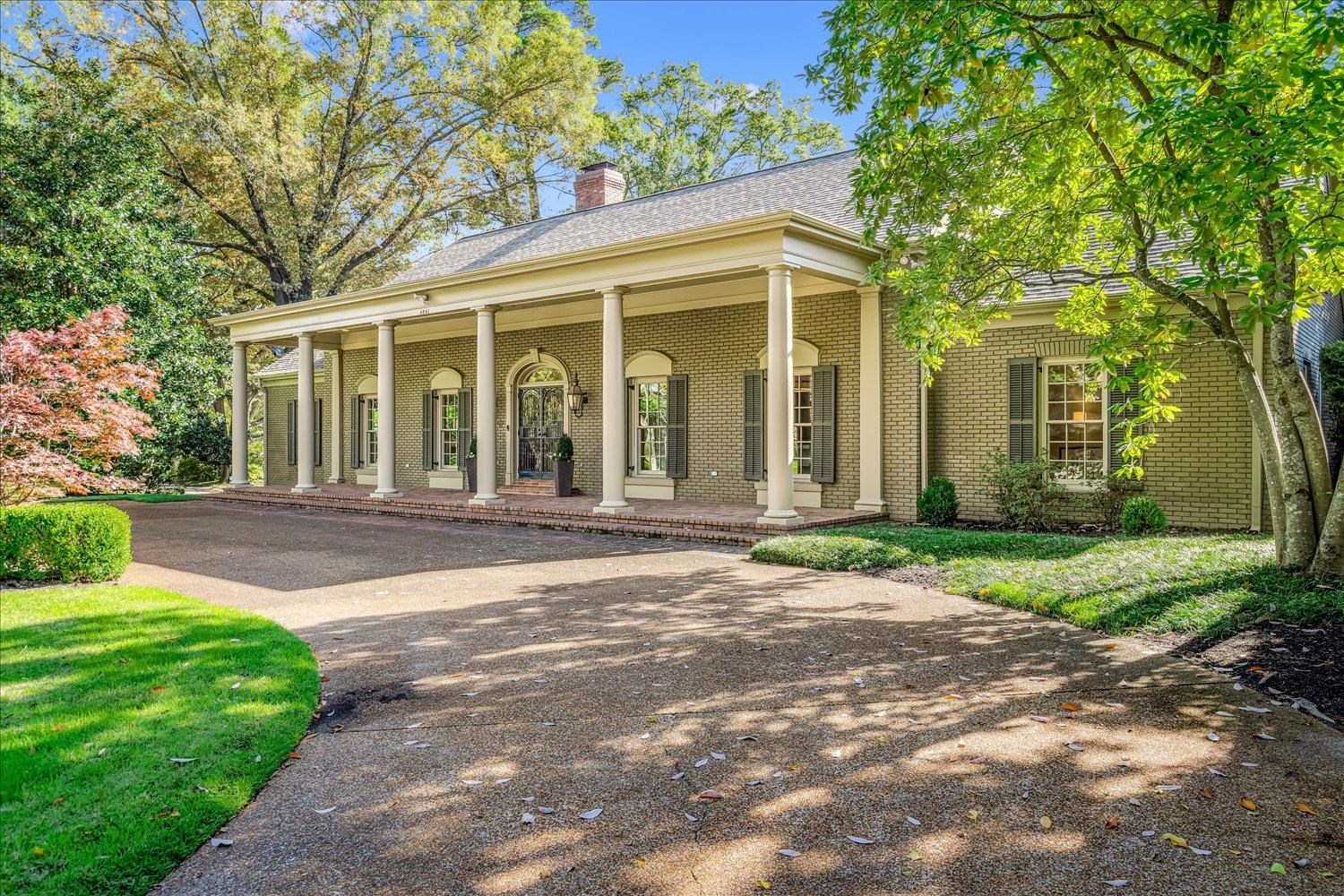 a front view of a house with a yard and potted plants