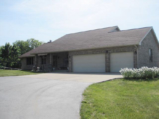 6966 North Marrill Road Byron, IL 61010 - Photo 1 of 11 a front view of a house with a yard and garage