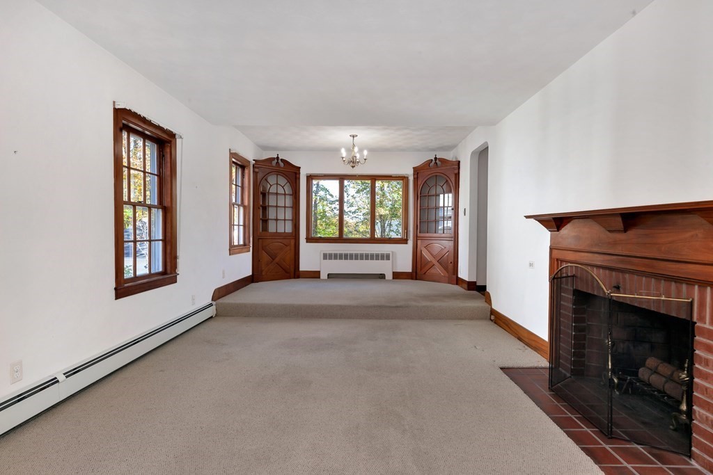 8 Tower Road Lexington, MA 02421 - Photo 7 of 39 a view of an empty room with windows and fireplace
