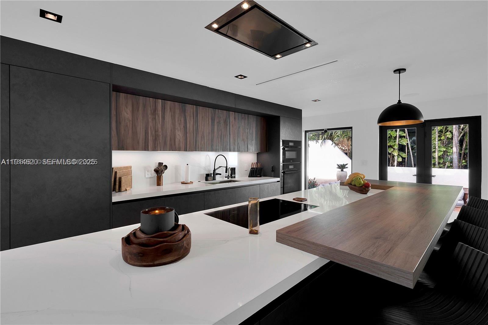 3760 Douglas Road Miami, FL 33133 - Photo 13 of 70 a kitchen with stainless steel appliances a dining table and chairs