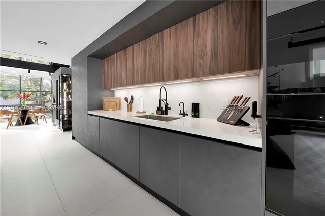 a kitchen with stainless steel appliances kitchen island granite countertop a sink and a refrigerator