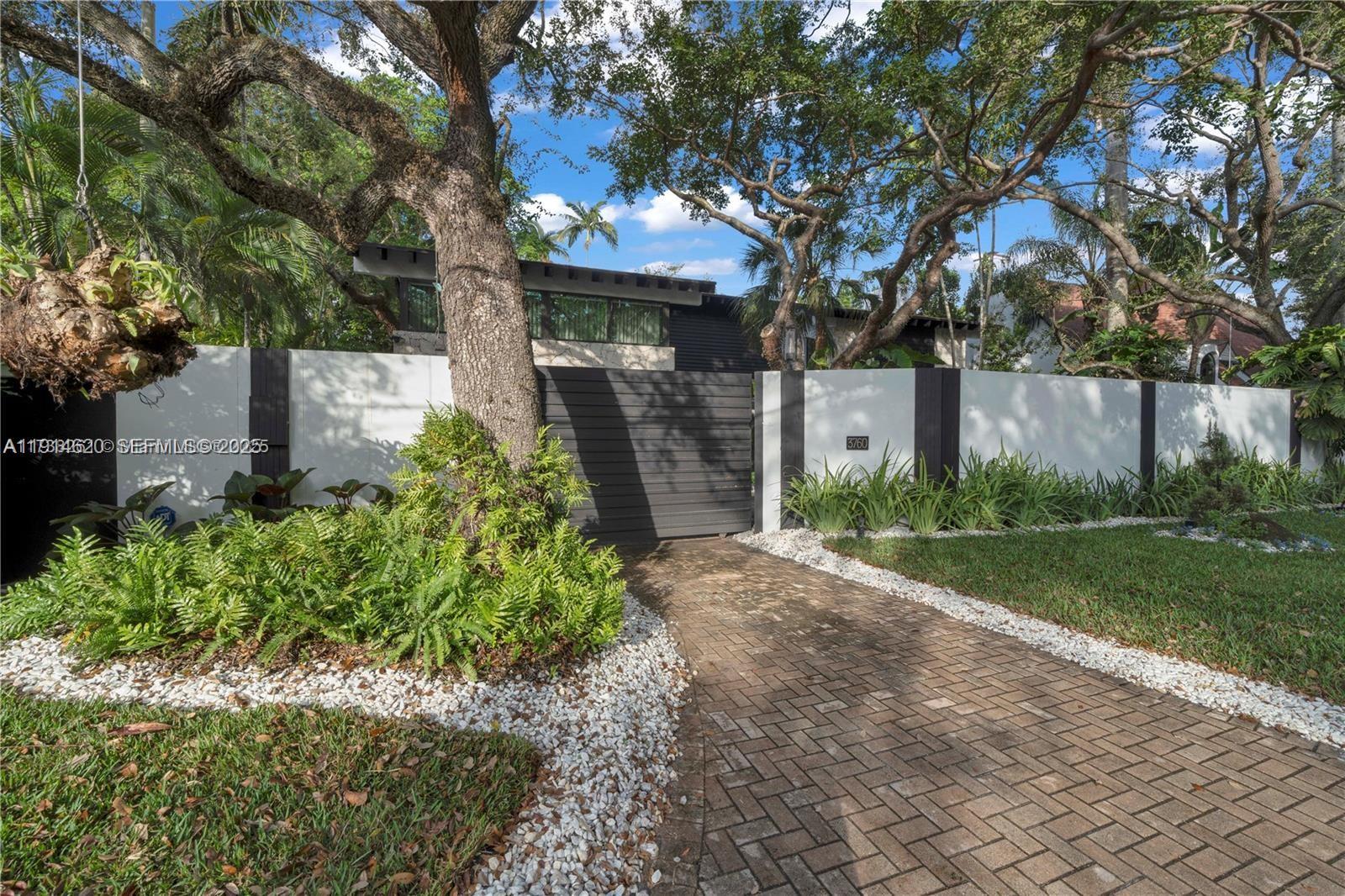 3760 Douglas Road Miami, FL 33133 - Photo 2 of 70 a front view of a house with garden