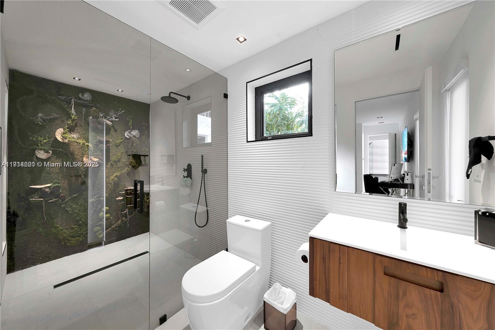 3760 Douglas Road Miami, FL 33133 - Photo 39 of 70 a bathroom with a toilet a sink a mirror and shower