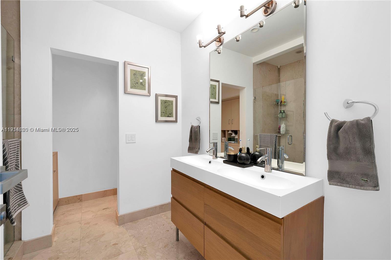 3760 Douglas Road Miami, FL 33133 - Photo 55 of 70 a bathroom with a sink vanity and a mirror