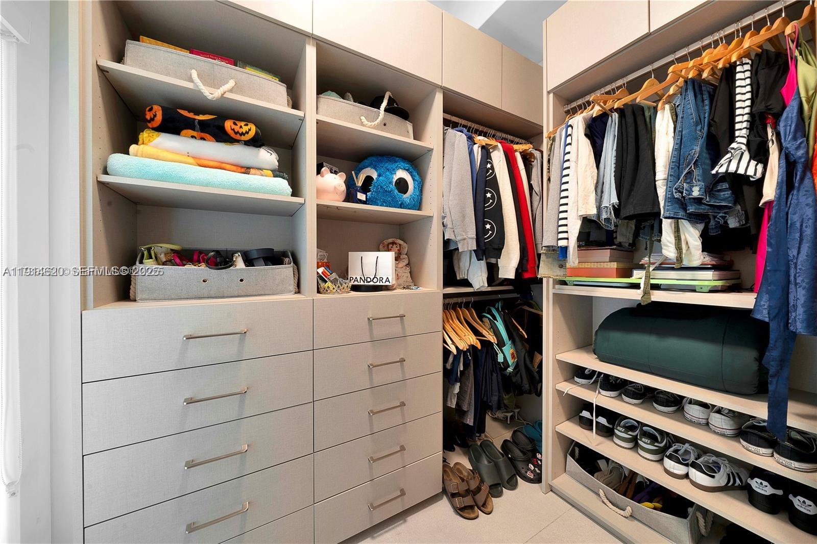 3760 Douglas Road Miami, FL 33133 - Photo 58 of 70 a view of walk in closet with clothes and shoes