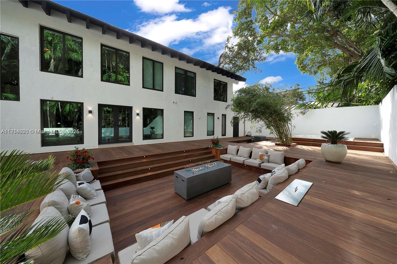 3760 Douglas Road Miami, FL 33133 - Photo 64 of 70 a view of a patio with couches table and chairs with wooden floor and fence