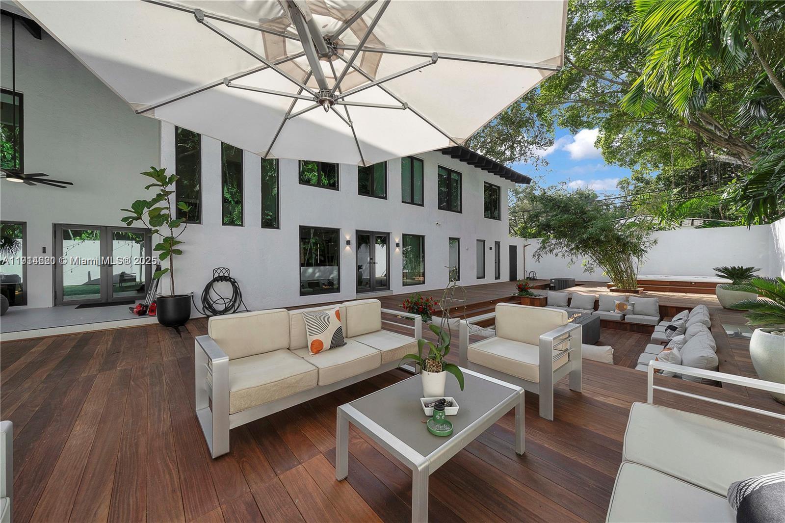3760 Douglas Road Miami, FL 33133 - Photo 68 of 70 a view of a patio with couches table and chairs with wooden floor and fence