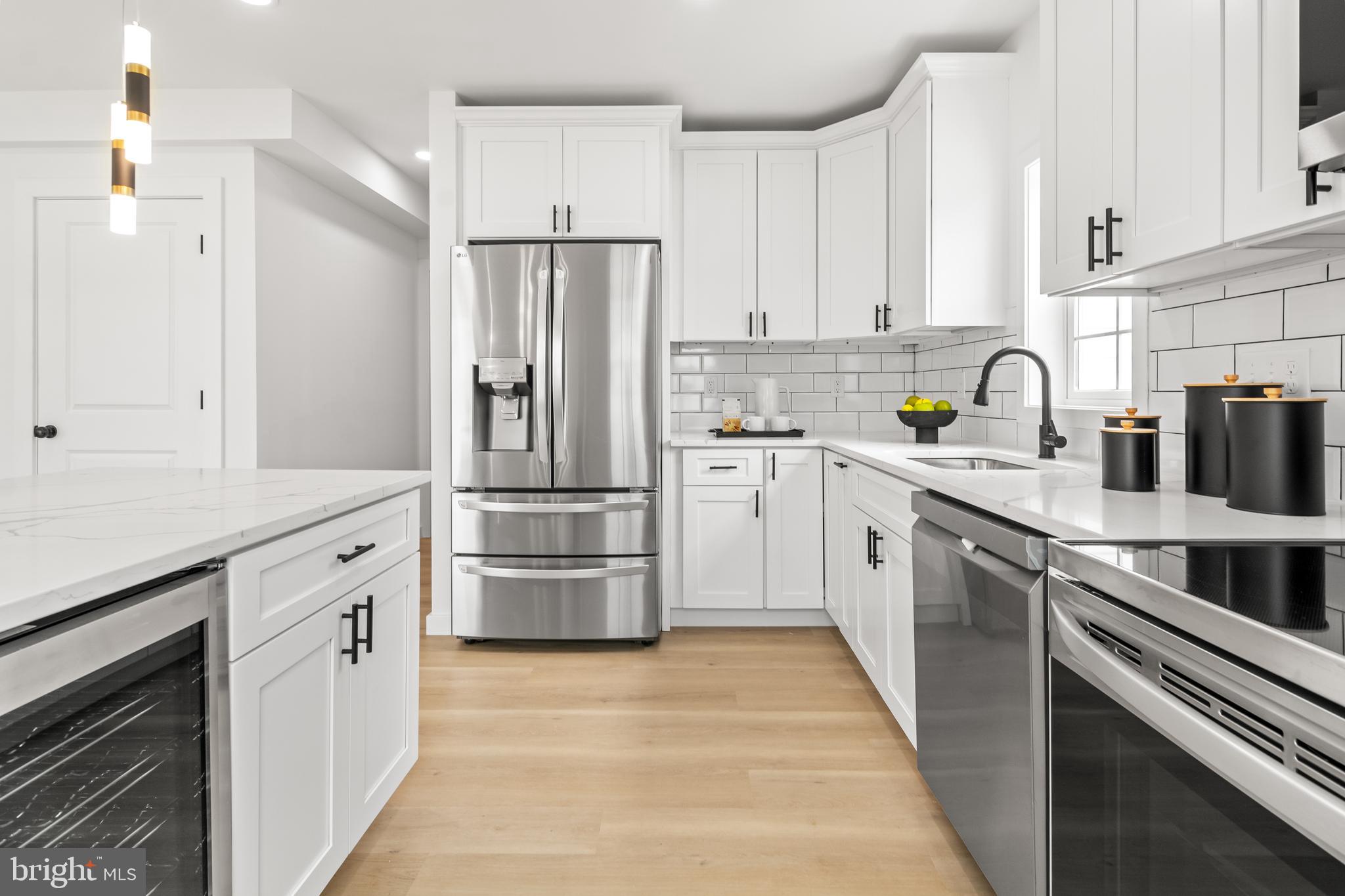 7817 Liberty Road Windsor Mill, MD 21244 - Photo 17 of 50 a kitchen with white cabinets and stainless steel appliances