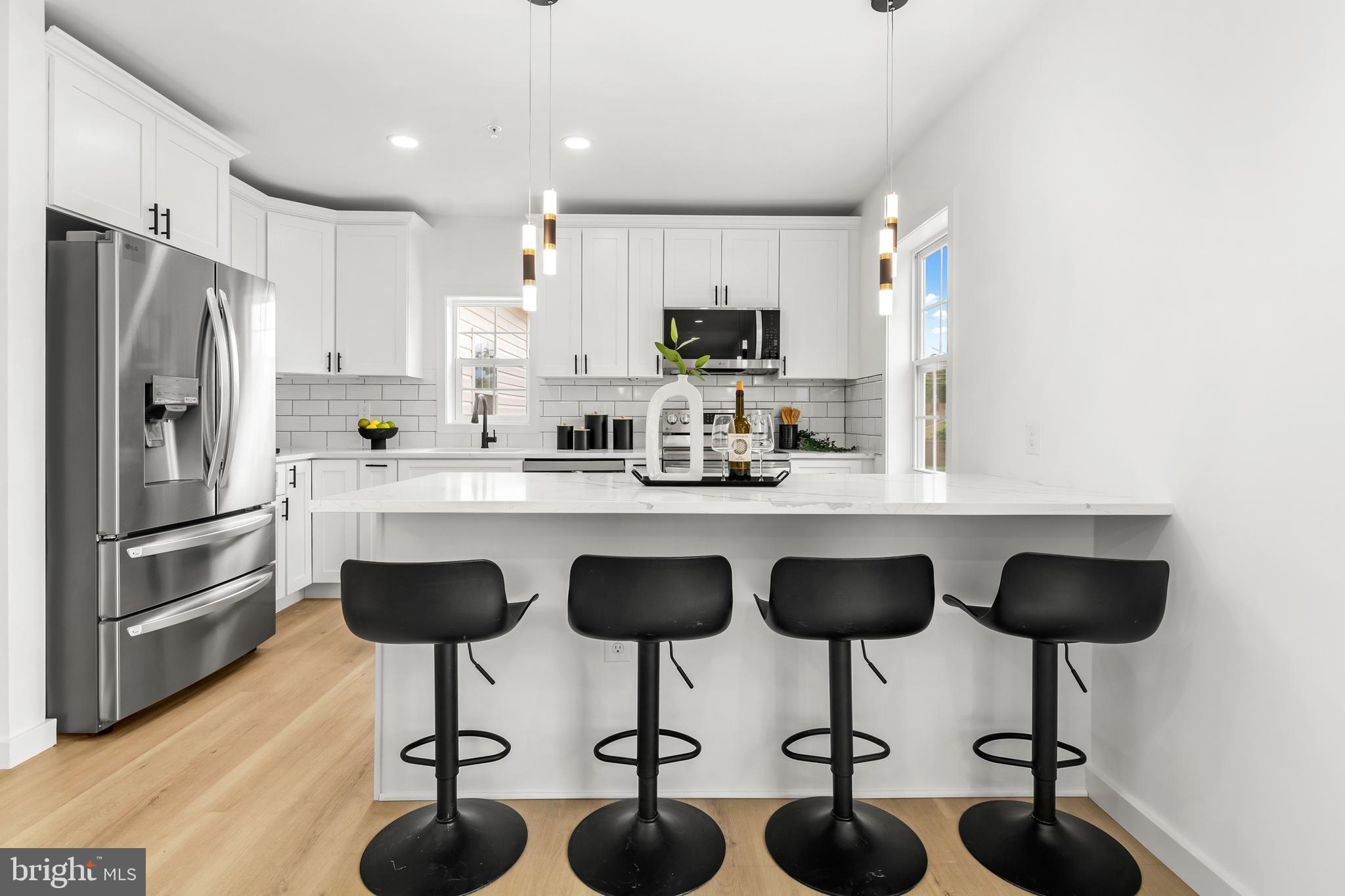7817 Liberty Road Windsor Mill, MD 21244 - Photo 20 of 50 a kitchen with granite countertop a counter space chairs stainless steel appliances and cabinets