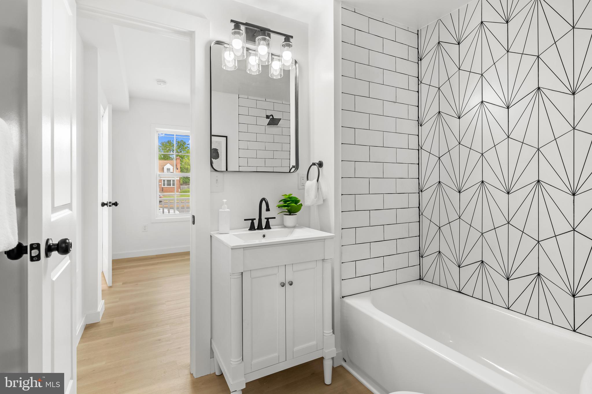 7817 Liberty Road Windsor Mill, MD 21244 - Photo 23 of 50 a bathroom with a bathtub a sink a window and a shower